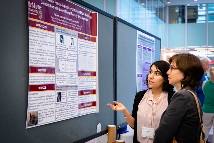 Two women look at a MIRA research poster