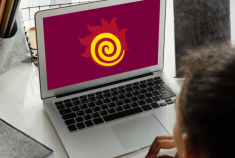 A fireball is on a laptop screen being used by a person