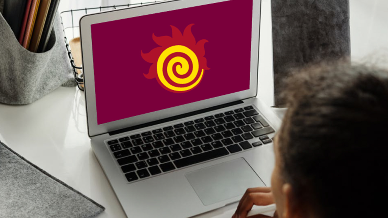A fireball is on a laptop screen being used by a person