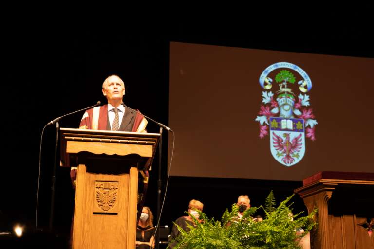 McMaster University President David Farrar speaks at the podium.