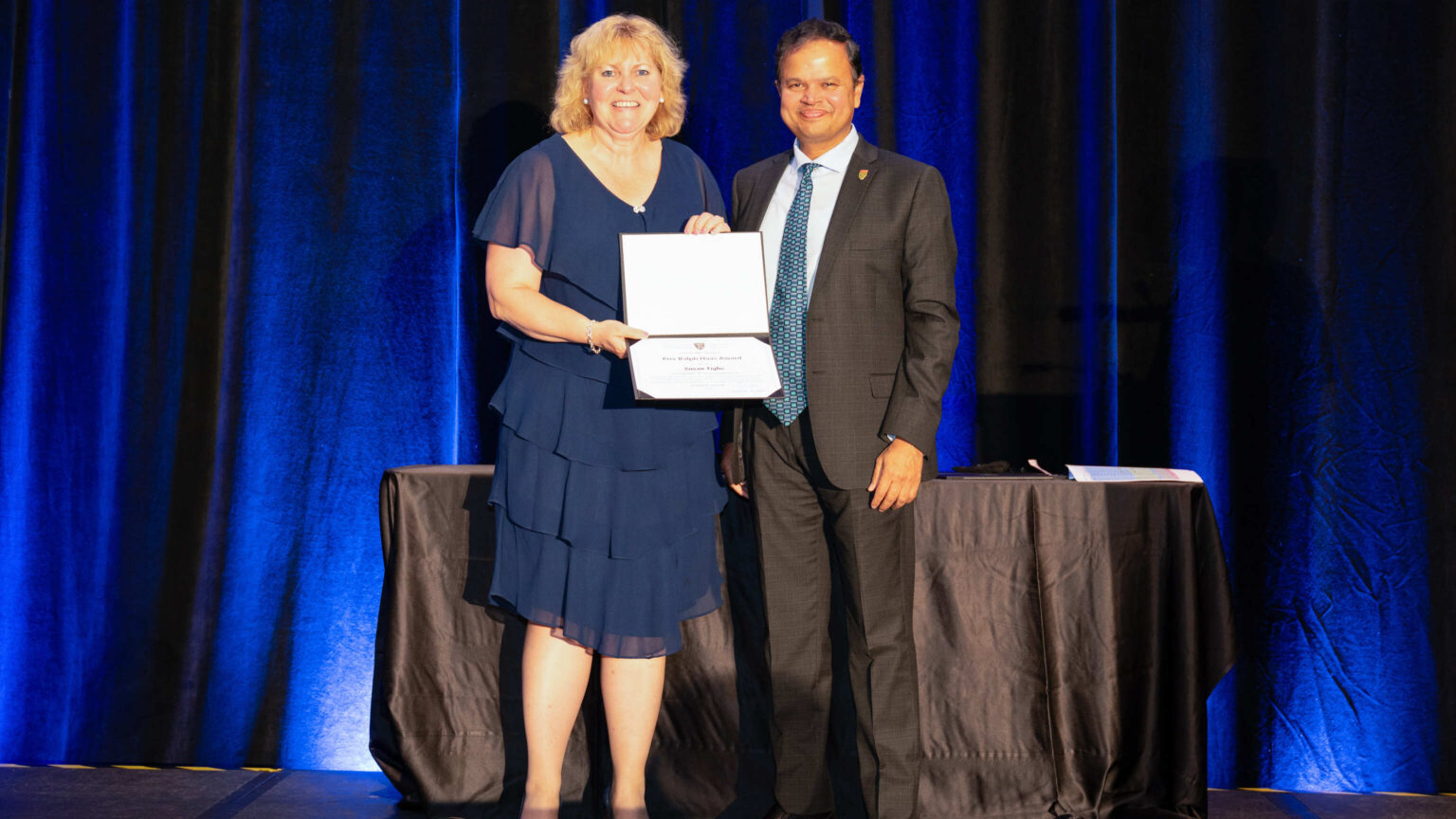 Susan Tighe on stage accepting an award.