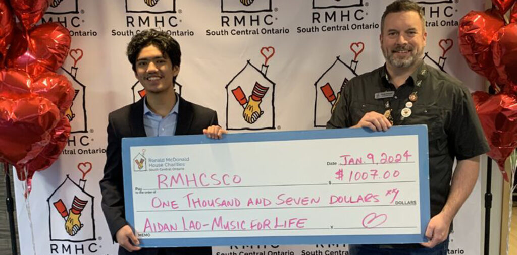 Aidan Lao presenting a cheque for just over $1000 to the Ronald McDonald House Charity