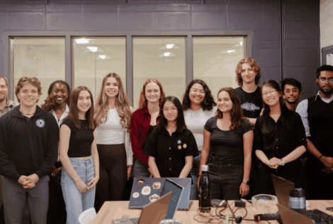 group of students posing with instructor in a classroom.