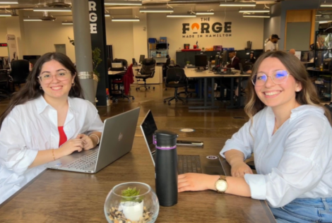 Two McMaster students in The Forge on campus. The space's name is written in the background on the wall.