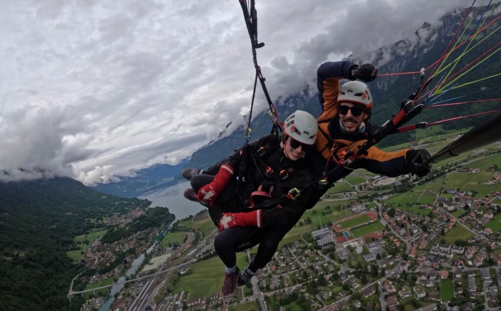 a woman paragliding over a lake. 