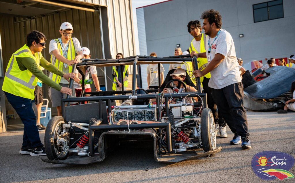 Solar Car team moving car to assemble