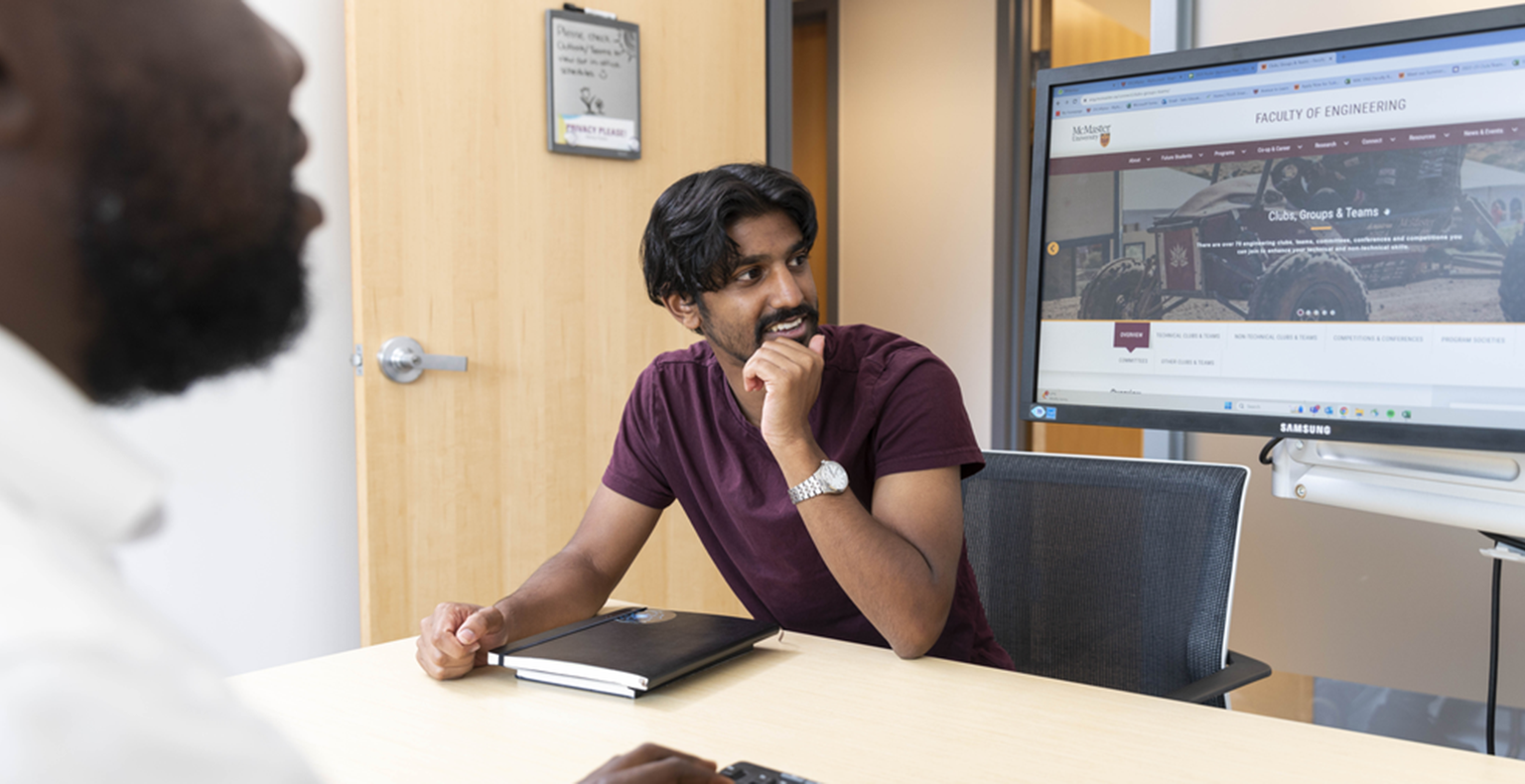 Student looking at computer screen with hand on chin