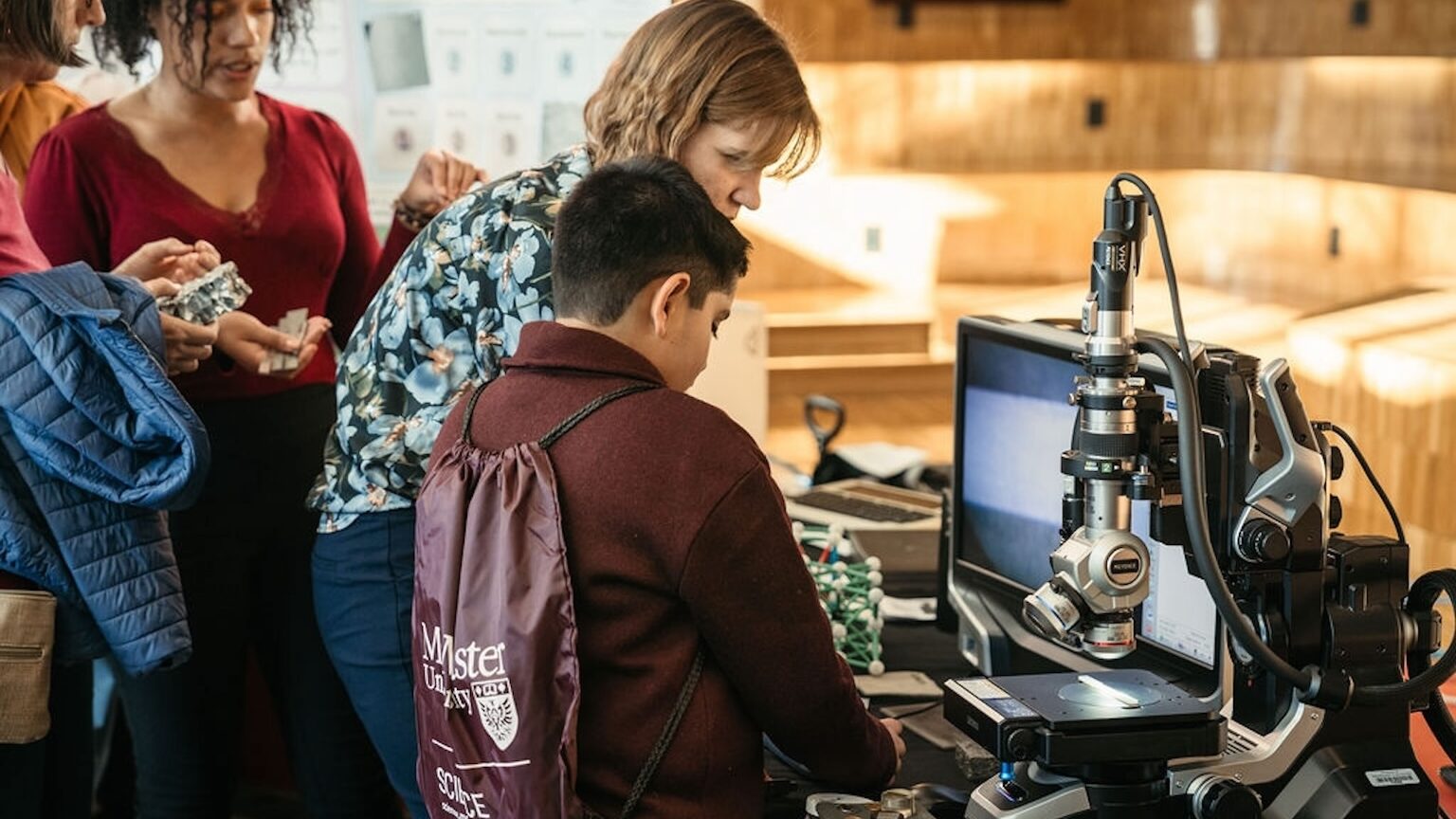 an adult and child looking at a science experiment.