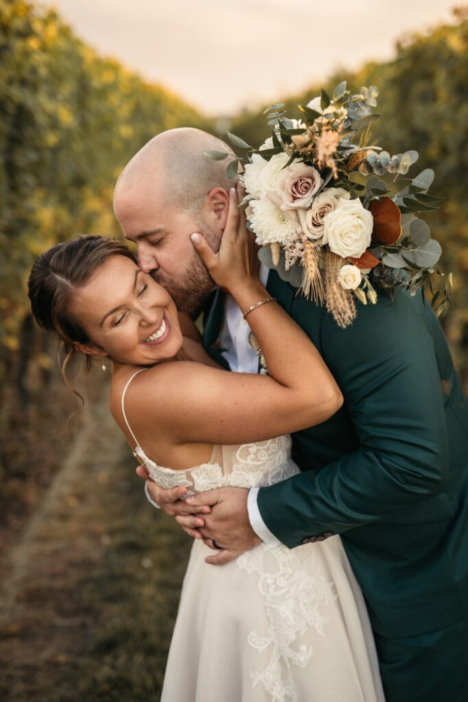 Couple on their wedding day smiling and kissing