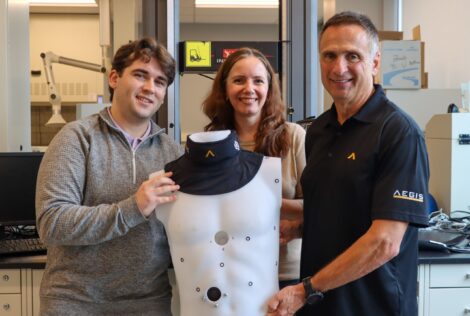 Carson Breweer, Cheryl Quenneville and Joe Camillo hold a mannequin torso that wears a hockey neck guard.