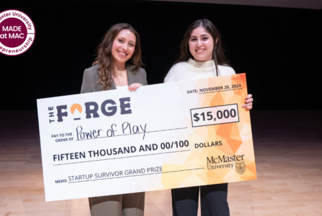 two women posing with a large cheque.