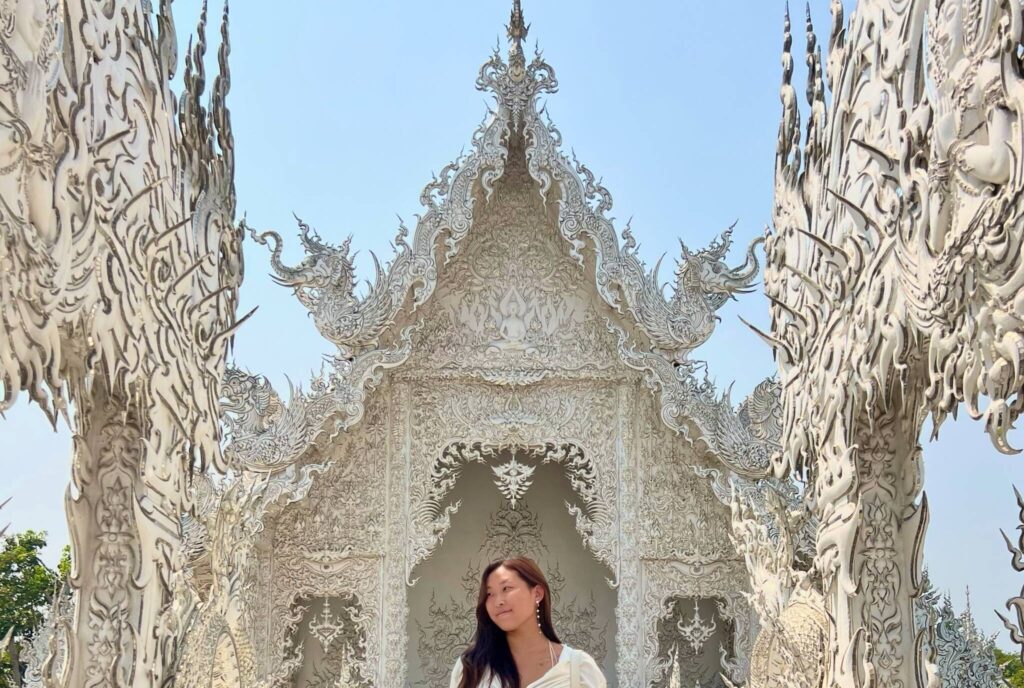 girl standing in a temple made up of all white materials.