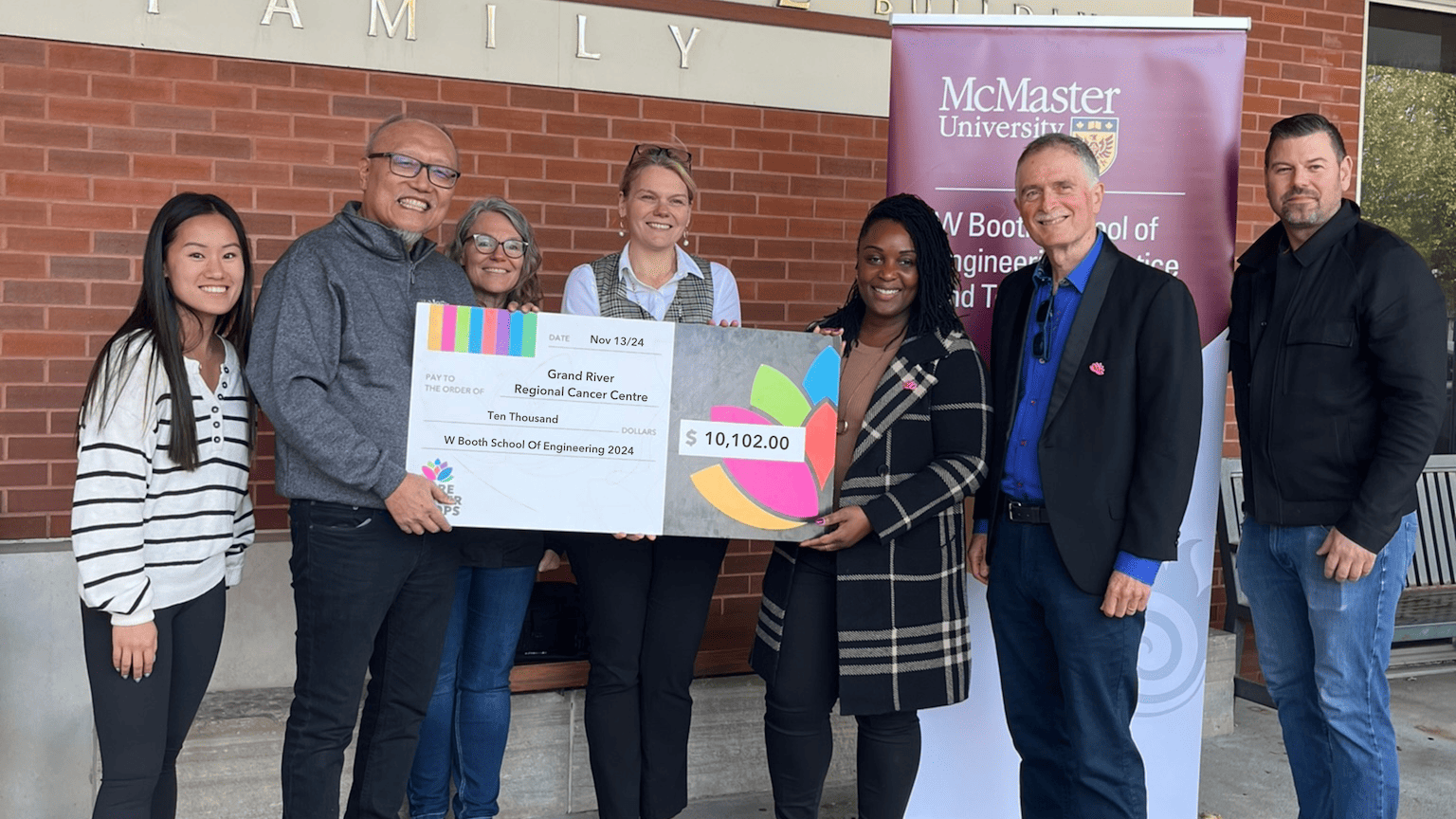 a group of people posing with a large cheque.