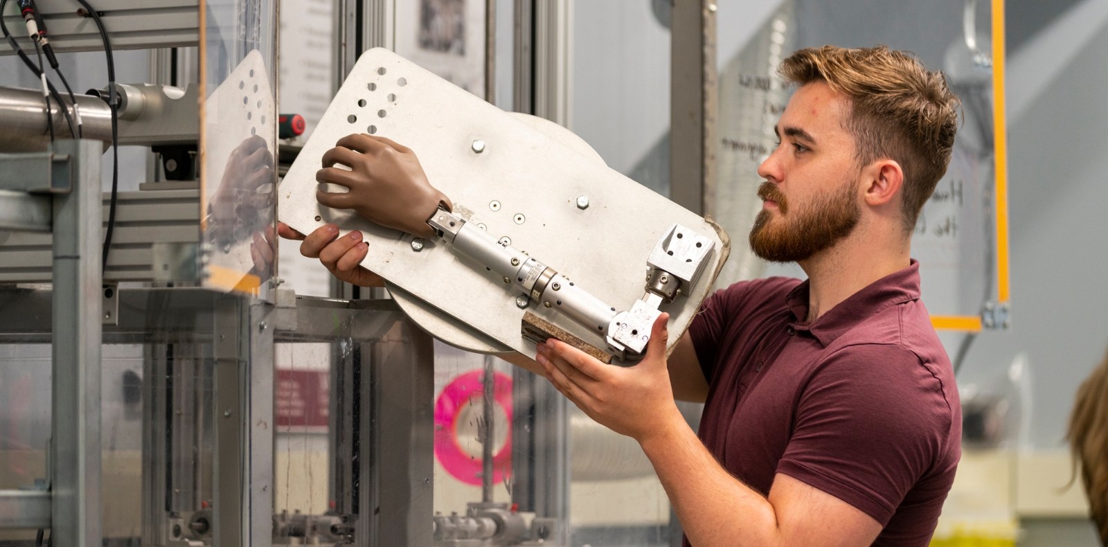 person holding a metal plate with a 3D printed prosthetic hand